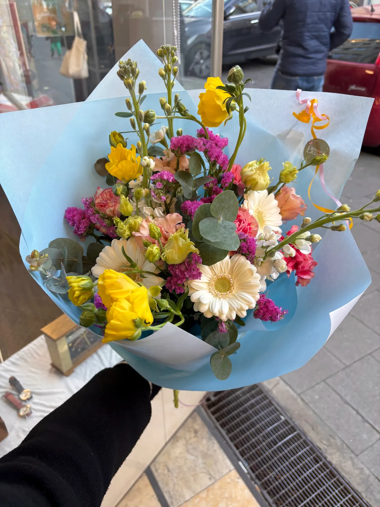 Bunter Strauß mit Gerbera, Freesien, Levkojen und Eukalyptus in hellblauem Papier